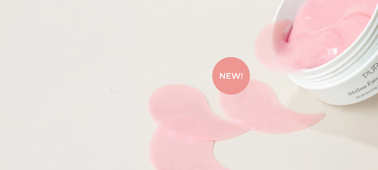 Mellow Eyes Dragonfruit: Open container spilling out pink eye patches against cream background (desktop)