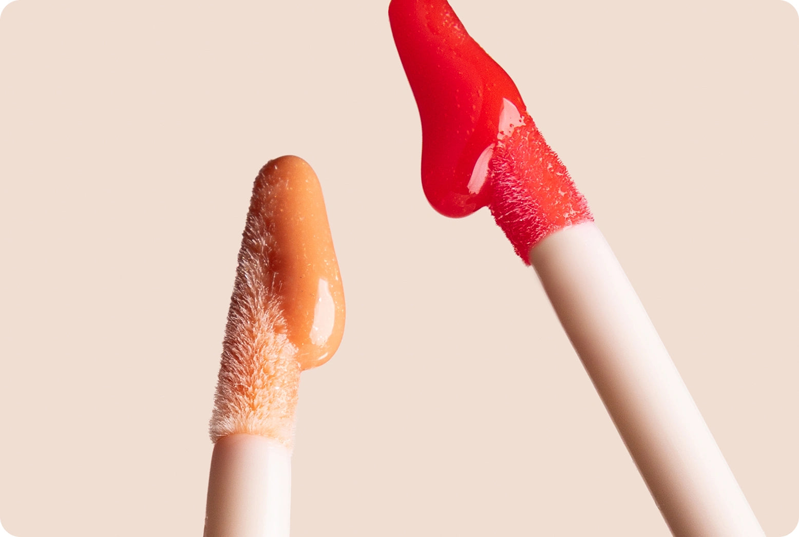 National Lipstick Day: 40% Off Lipstick - Glossy Lip Tint gloss wands dripping Cherry Crush and Guava Glow product against pale pink background