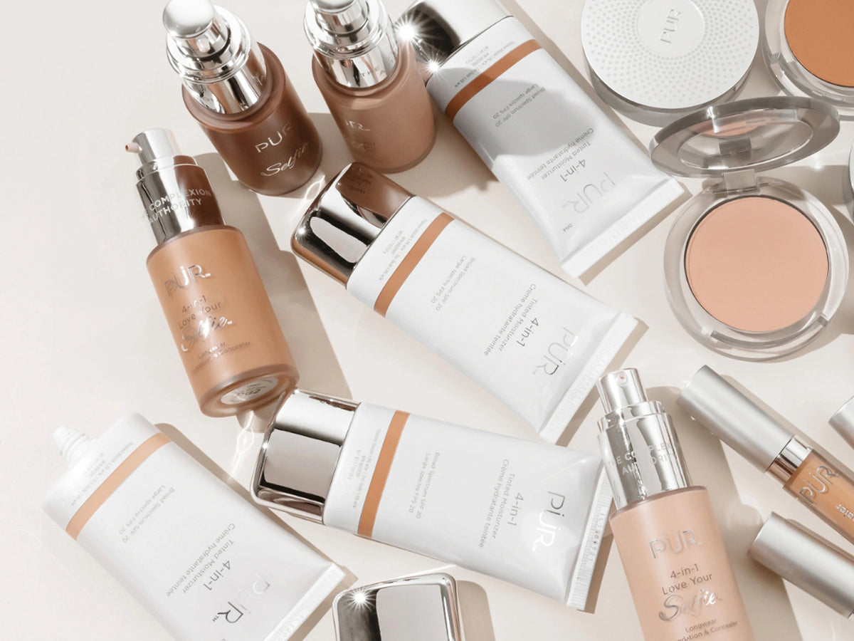 PUR complexion collection products against white background laying flat on a table top