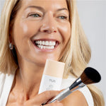 Model holding 2-in-1 Foundation & Finishing Brush and 4-in-1 Skin Tint SPF 50 